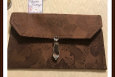 Brown clutch purse with a lead crystal purse charm